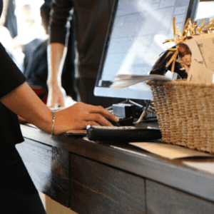 tight shot of woman's hand operating till in retail space