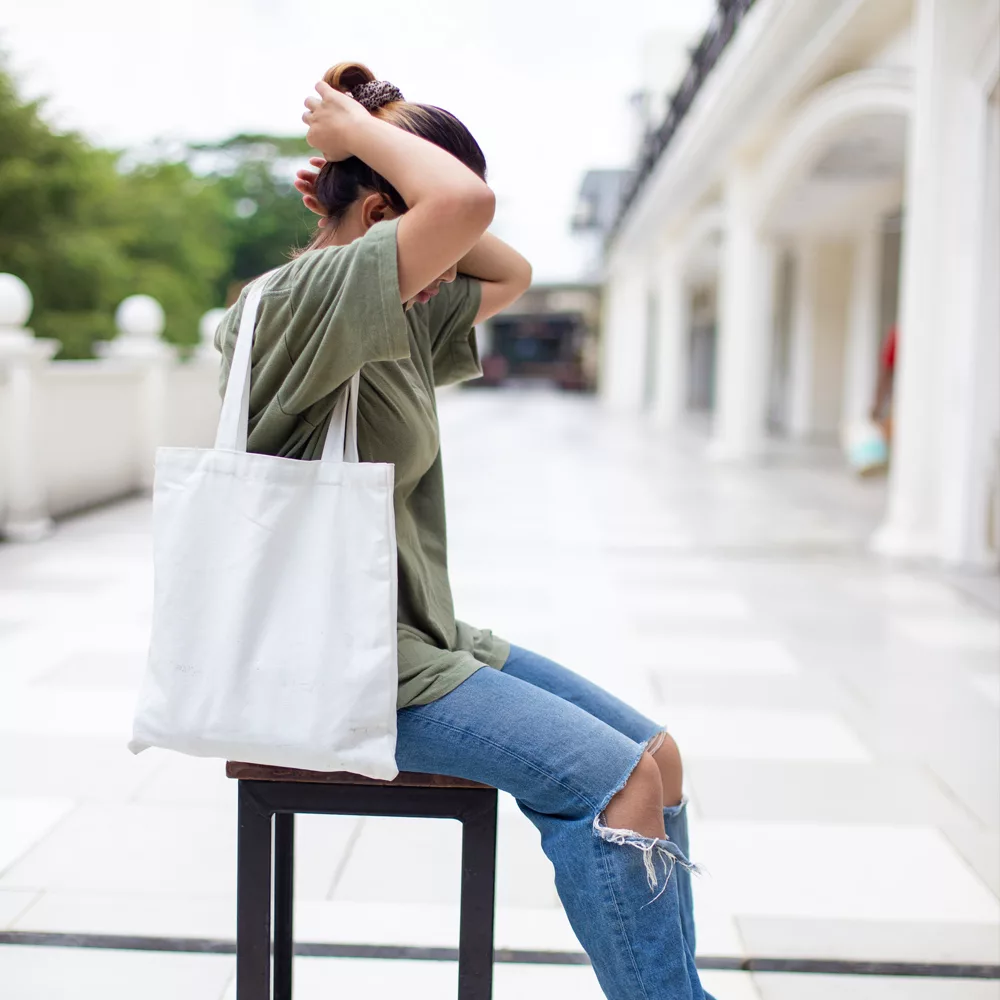 Person holding a branded jute shopping bag