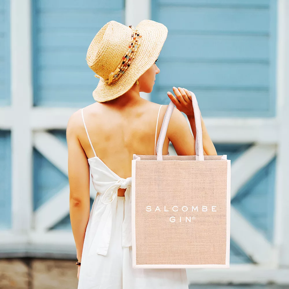 Person holding a branded jute shopping bag