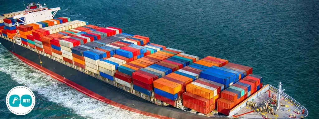 piles of colourful shipping containers piled high on large ship sailing across the sea