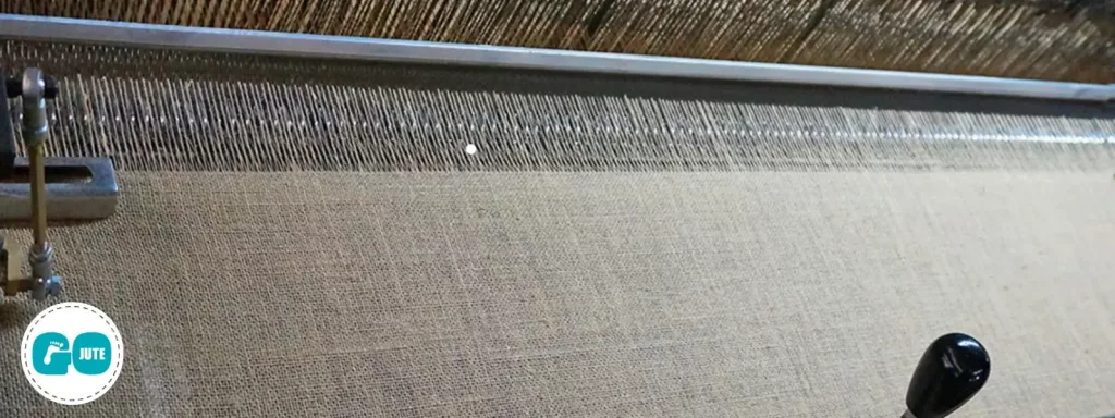 industrial machine weaving threads into sheets of jute fabric