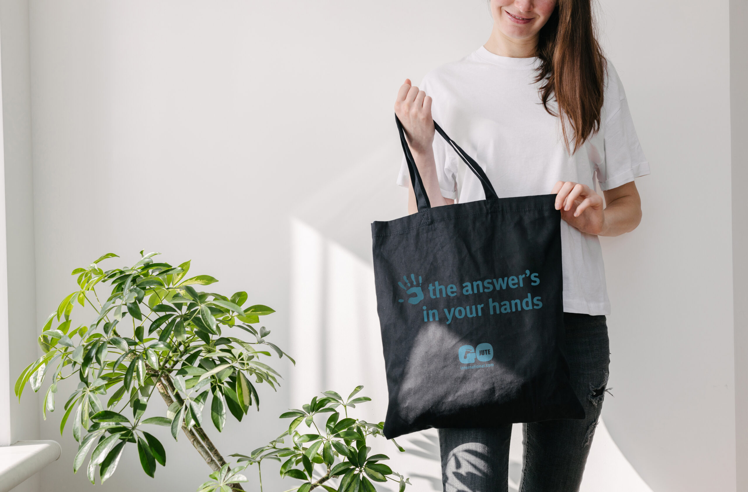 Person holding a branded jute shopping bag