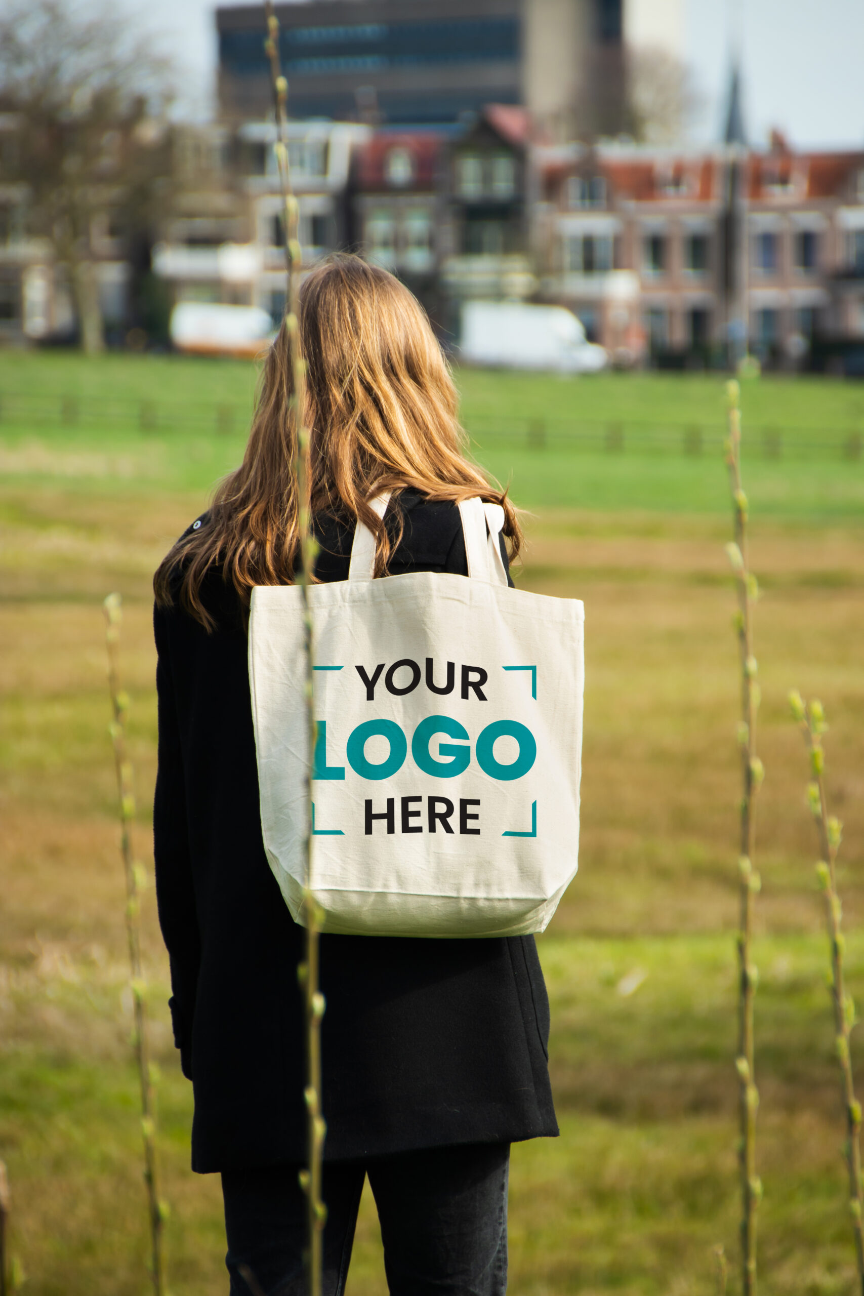 Person holding a branded jute shopping bag