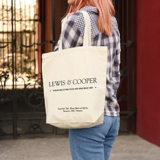 Young woman with cotton bag on city street, closeup. Mockup for design